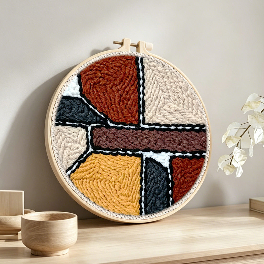 Abstract geometric color blocks punch needle artwork displayed on a table