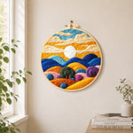 Abstract wavy clouds and colorful hills needle felt wall art displayed in a bright home interior