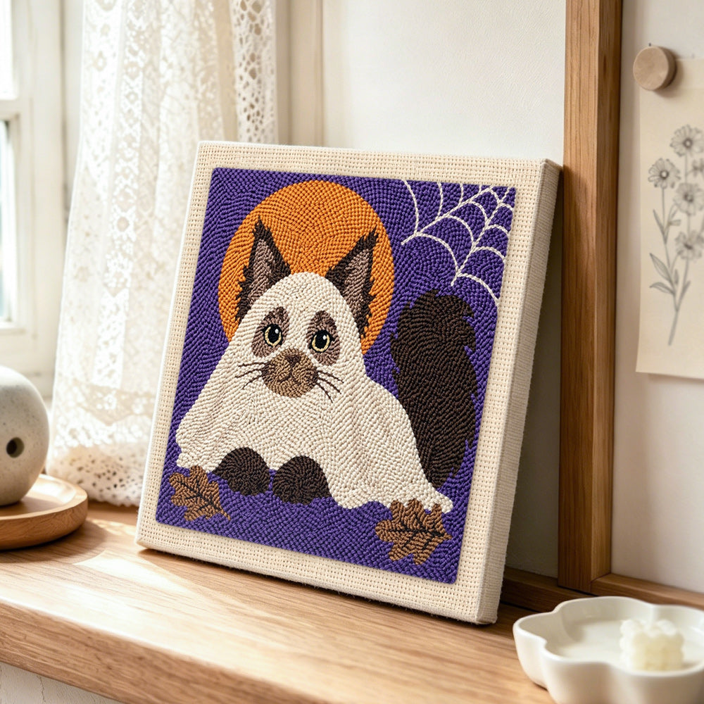 Adorable cat in ghost costume punch needle artwork displayed on a table
