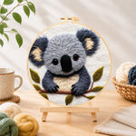 Finished adorable fluffy koala needle felting displayed on a wooden easel