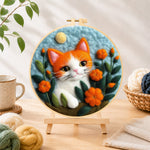 Finished adorable orange and white kitten needle felting displayed on a wooden easel