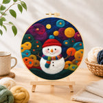 Finished adorable snowman with scarf needle felting displayed on a wooden easel