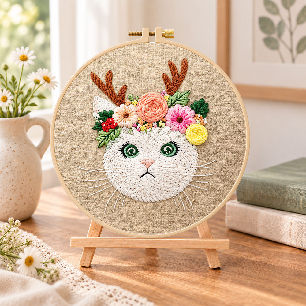 Antler flower kitten embroidery kit finished hoop displayed on a wooden stand as cozy tabletop decor