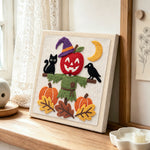 Apple scarecrow scene punch needle artwork displayed on a table