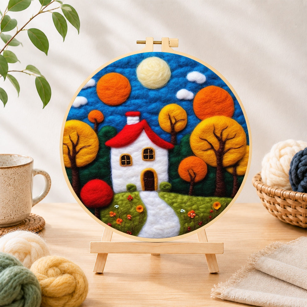 Finished autumn fairy tale tree and house needle felting displayed on a wooden easel