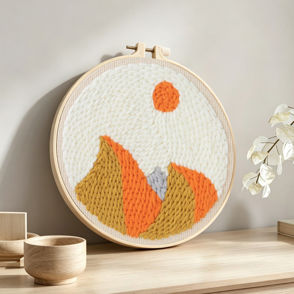 Autumn mountain with sun punch needle artwork displayed on a table