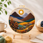 Finished autumn mountains and plants needle felting displayed on a wooden easel