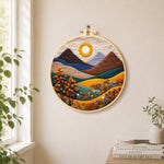 Autumn mountains and plants needle felt wall art displayed in a bright home interior
