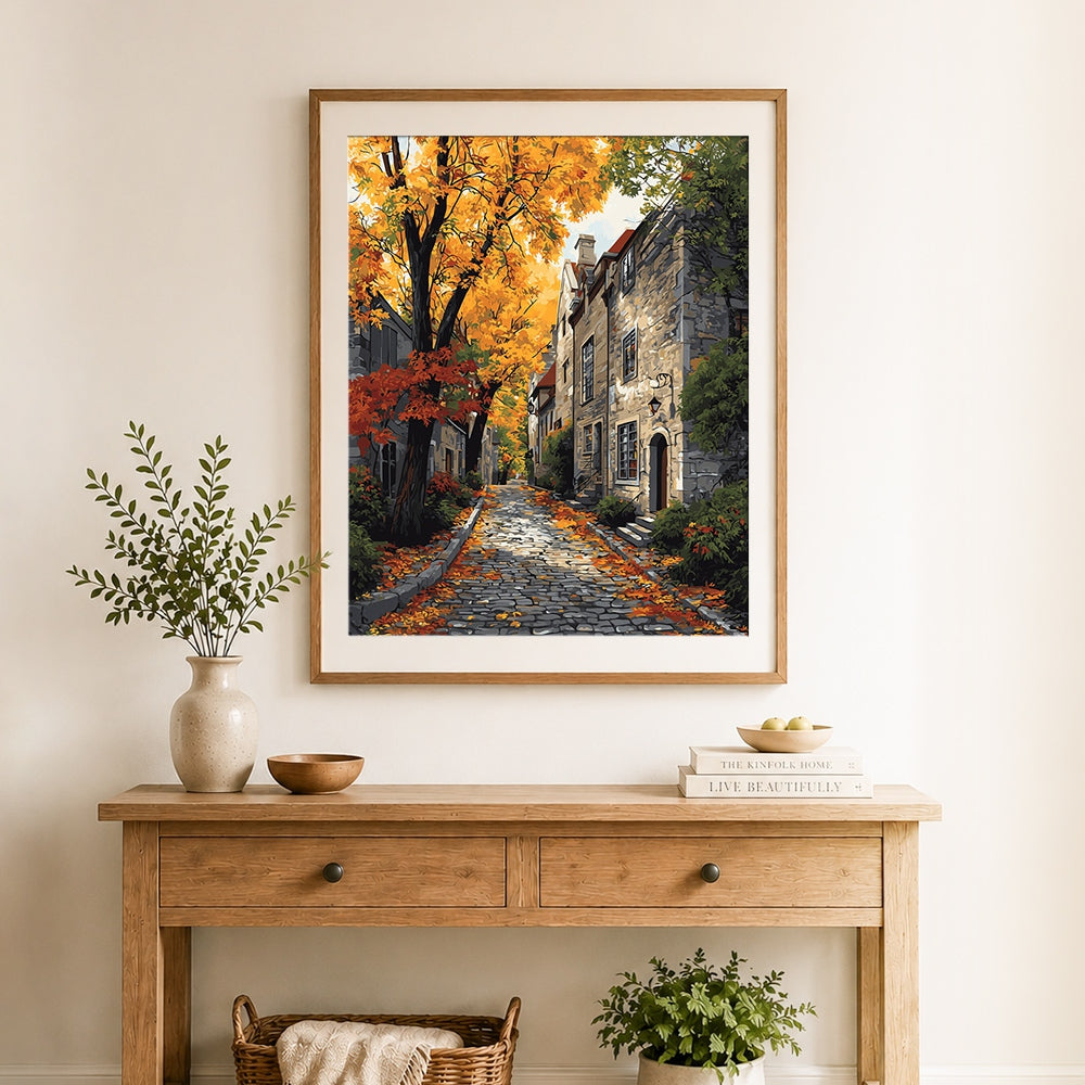 Finished autumn street with golden leaves and stone houses cross stitch artwork displayed as home decor