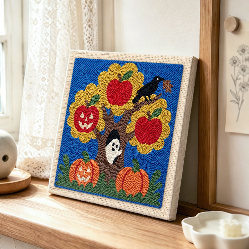 Autumn tree ghost scene punch needle artwork displayed on a table