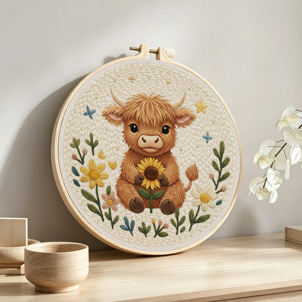 Baby highland cow and sunflower punch needle artwork displayed on a table