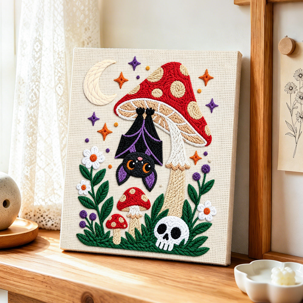 Bat hanging under mushroom punch needle artwork displayed on a table