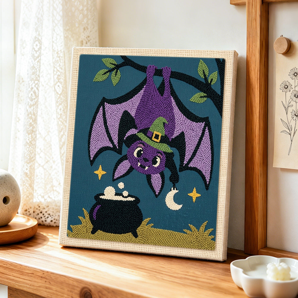 Bat hanging upside‑down punch needle artwork displayed on a table