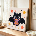 Bat with lollipop punch needle artwork displayed on a table