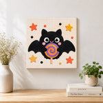 Finished bat with lollipop artwork displayed on a wall