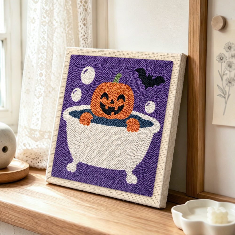 Bath time jack‑o‑lantern punch needle artwork displayed on a table