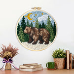 Finished bear in forest under moonlight artwork displayed on a wall