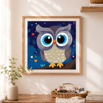 Finished big‑eyed night owl cross stitch artwork displayed as home decor