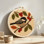Bird and berries punch needle artwork displayed on a table