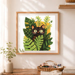 Finished black cat among green foliage cross stitch artwork displayed as home decor