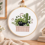 Black cat and cactus embroidery hoop wall art displayed as warm and cozy handmade home decor