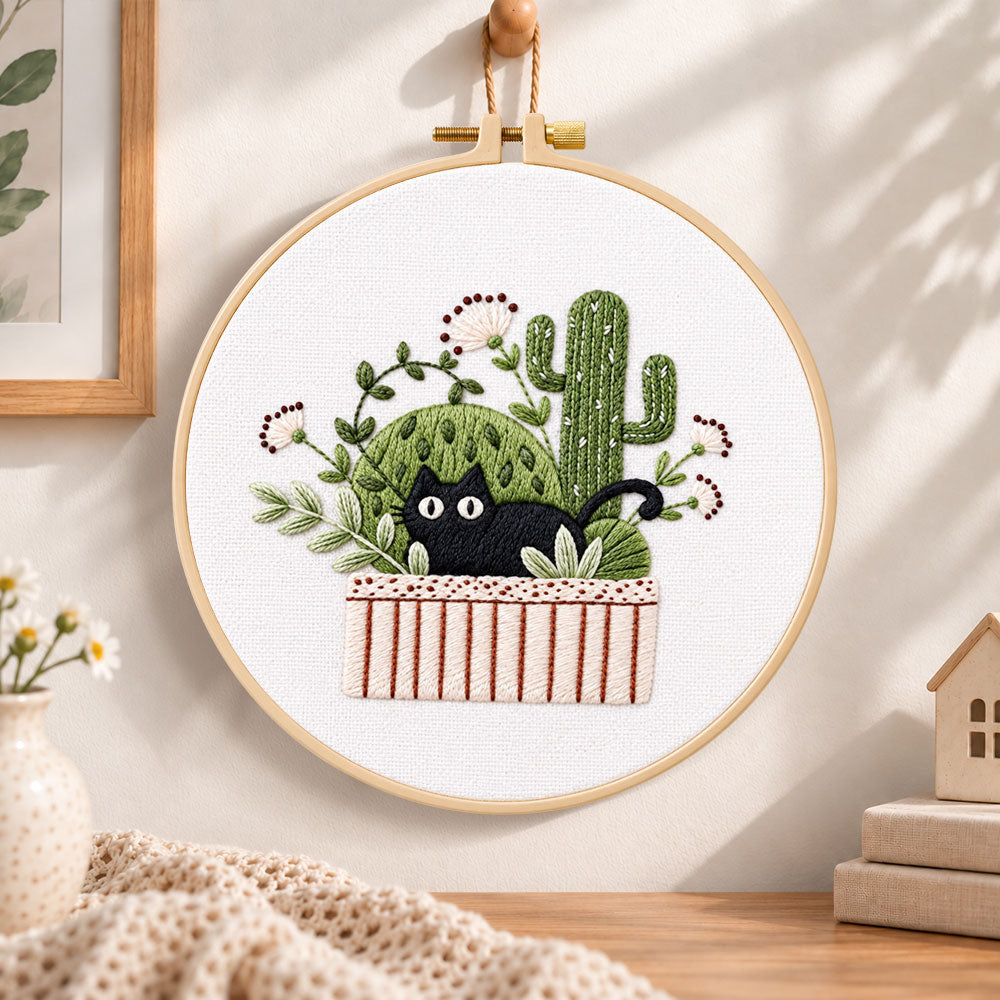 Black cat and cactus embroidery hoop wall art displayed as warm and cozy handmade home decor