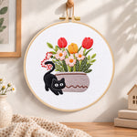Black cat and tulips embroidery hoop wall art displayed as warm and cozy handmade home decor