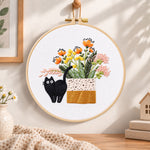 Black cat and wildflowers embroidery hoop wall art displayed as warm and cozy handmade home decor