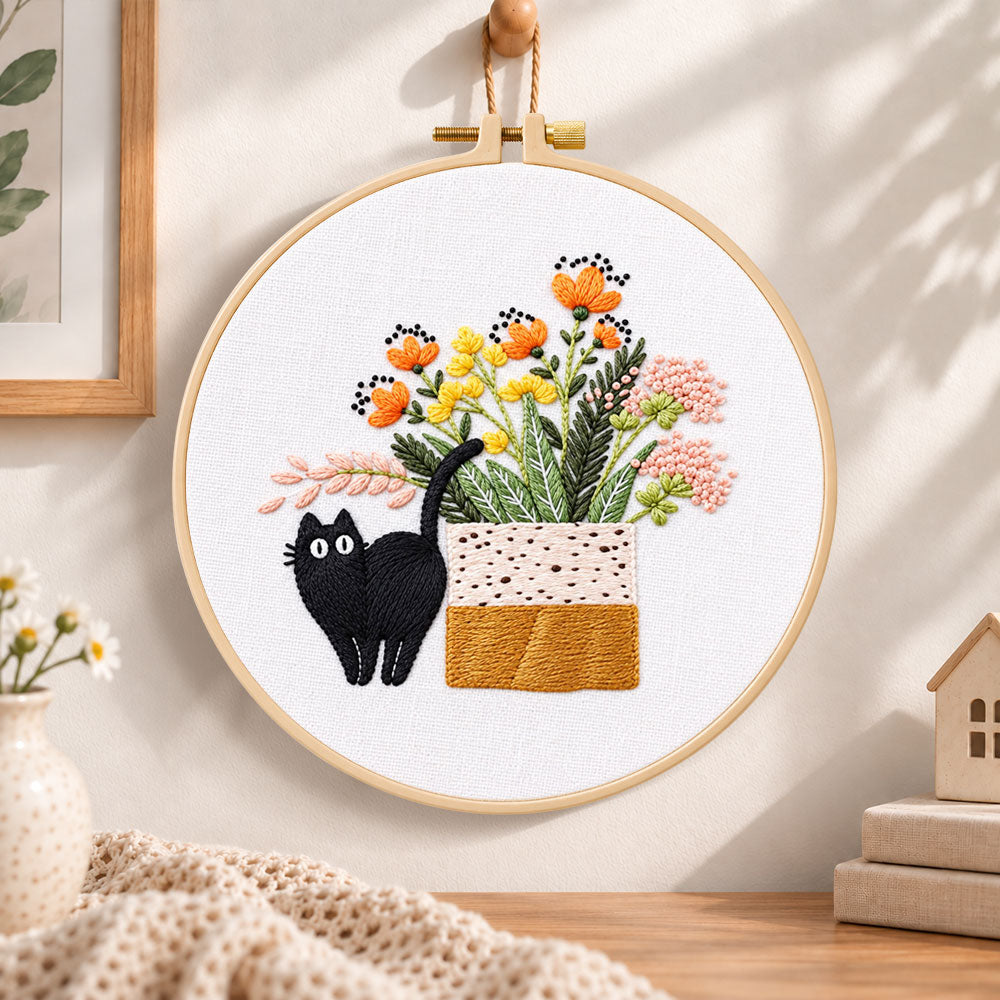 Black cat and wildflowers embroidery hoop wall art displayed as warm and cozy handmade home decor