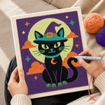 Creating handmade black cat beneath moon punch needle artwork
