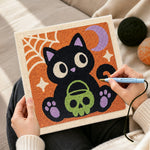 Creating handmade black cat holding skull treat bucket punch needle artwork