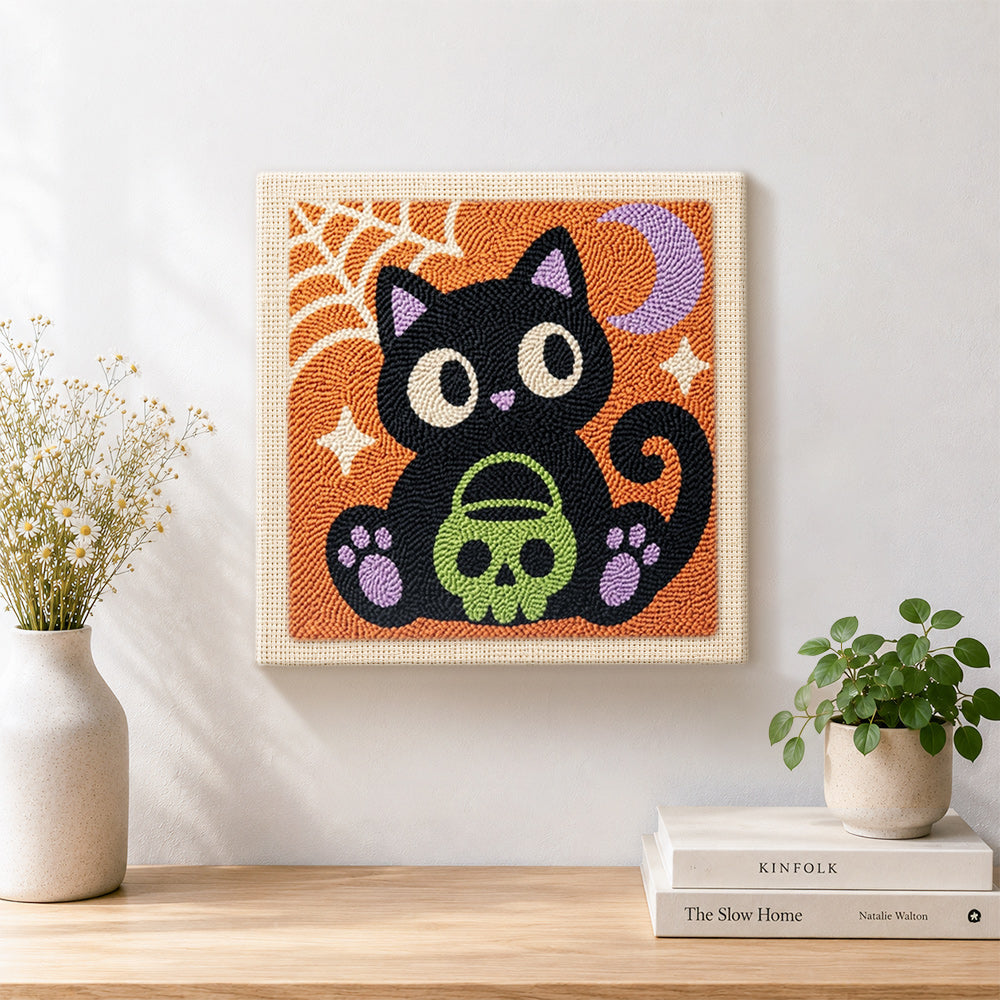 Finished black cat holding skull treat bucket artwork displayed on a wall