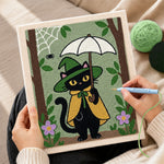 Creating handmade black cat holding white umbrella punch needle artwork