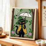 Black cat holding white umbrella punch needle artwork displayed on a table