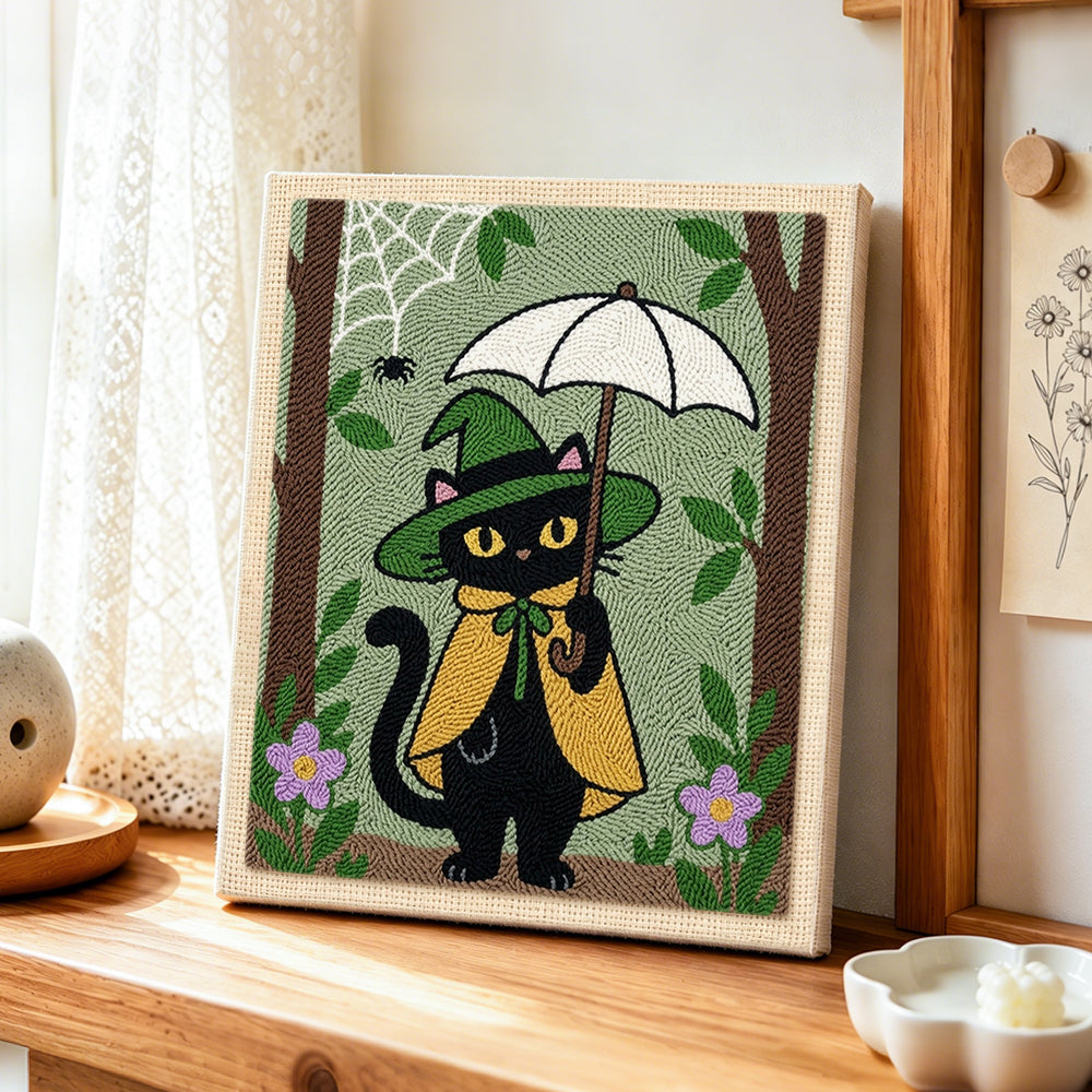 Black cat holding white umbrella punch needle artwork displayed on a table