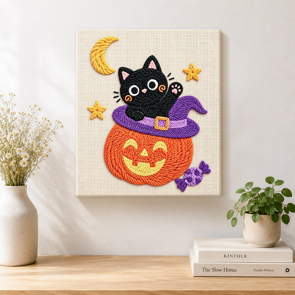 Finished black cat inside pumpkin hat artwork displayed on a wall