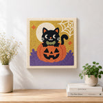 Finished black cat on pumpkin artwork displayed on a wall
