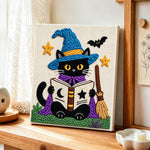 Black cat reading magic book punch needle artwork displayed on a table
