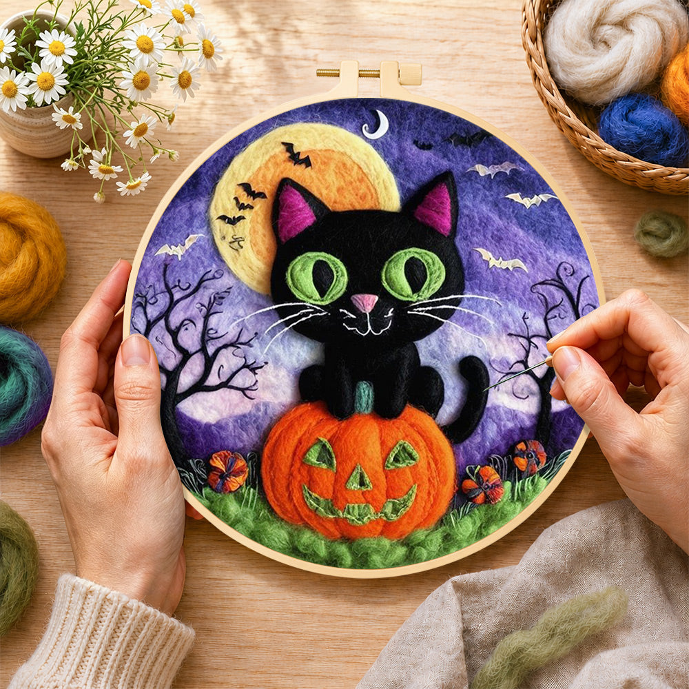 Creating the black cat with green eyes on pumpkin wool painting by hand with a felting needle