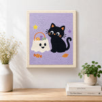 Finished black cat with trick‑or‑treat bag artwork displayed on a wall