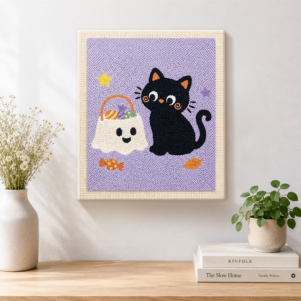Finished black cat with trick‑or‑treat bag artwork displayed on a wall
