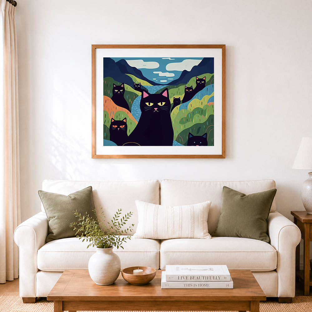 Finished black cats in stylized rolling hills cross stitch artwork displayed as home decor