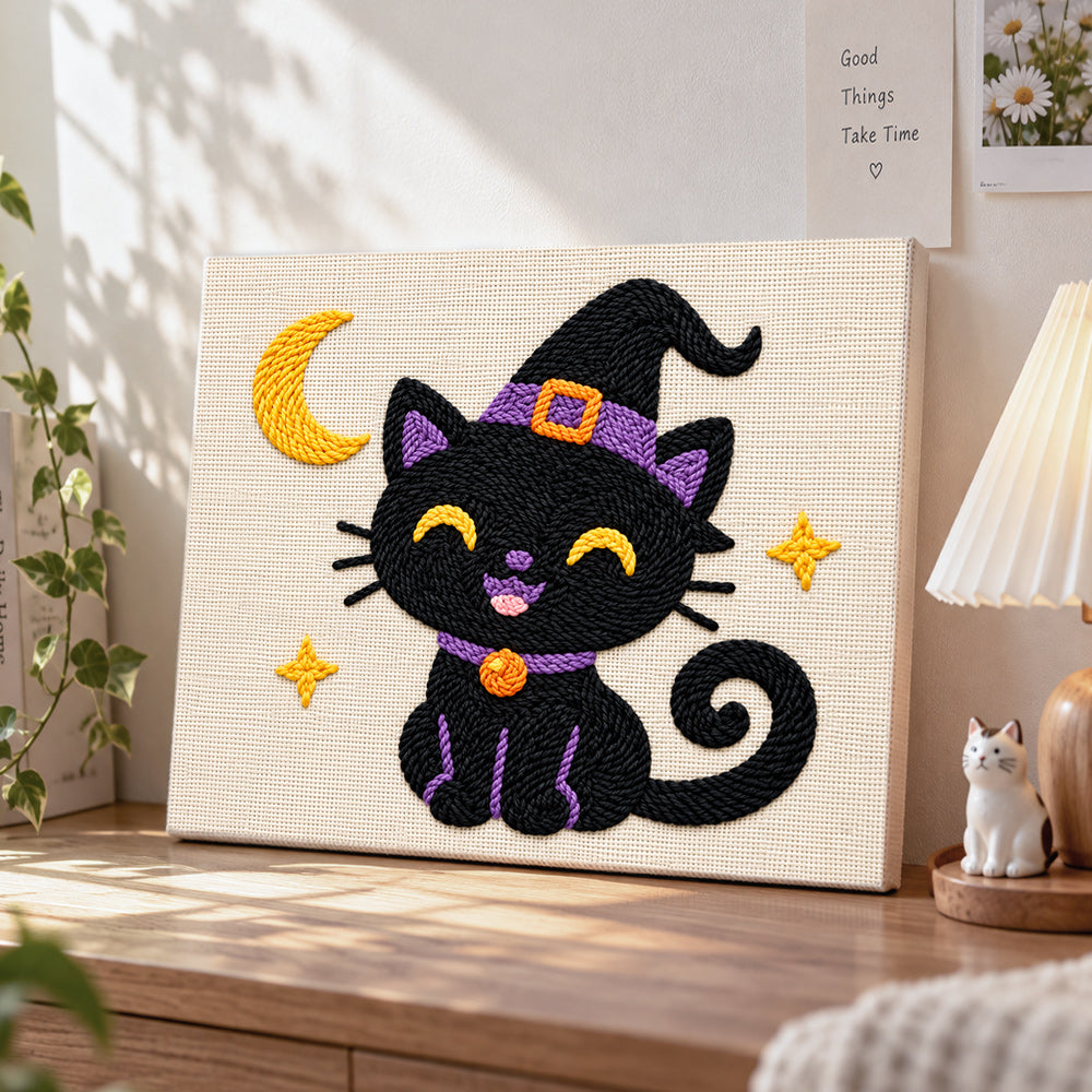 Black witch cat with crescent moon punch needle artwork displayed on a table