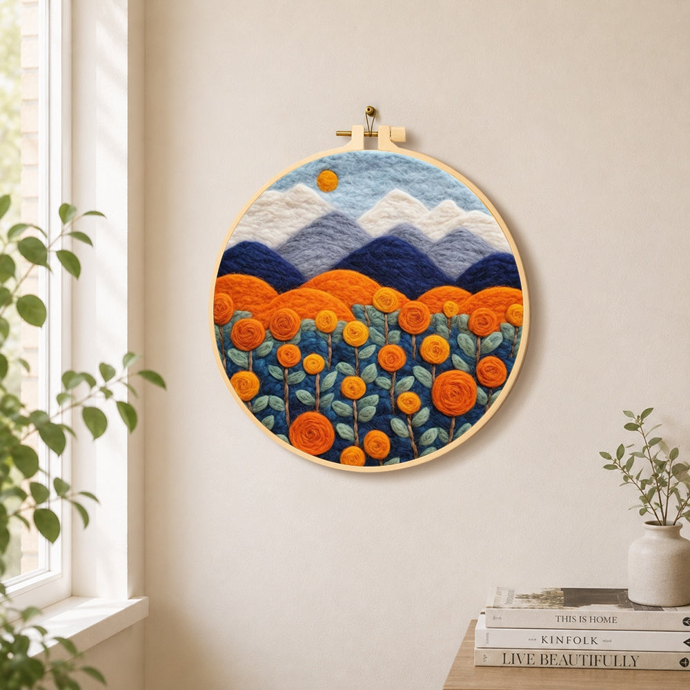 Blooming orange roses and mountains needle felt wall art displayed in a bright home interior