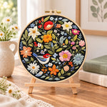 Blossom and bird art embroidery kit finished hoop displayed on a wooden stand as cozy tabletop decor