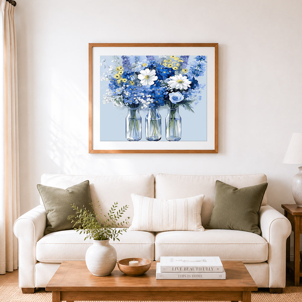 Finished blue and white floral bouquet in glass bottles cross stitch artwork displayed as home decor