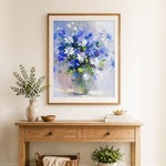Finished blue and white wildflowers in round vase cross stitch artwork displayed as home decor