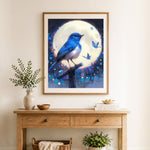 Finished blue bird bathed in moonlight cross stitch artwork displayed as home decor