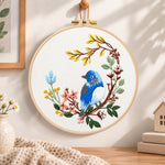 Blue bird on floral branch embroidery hoop wall art displayed as warm and cozy handmade home decor