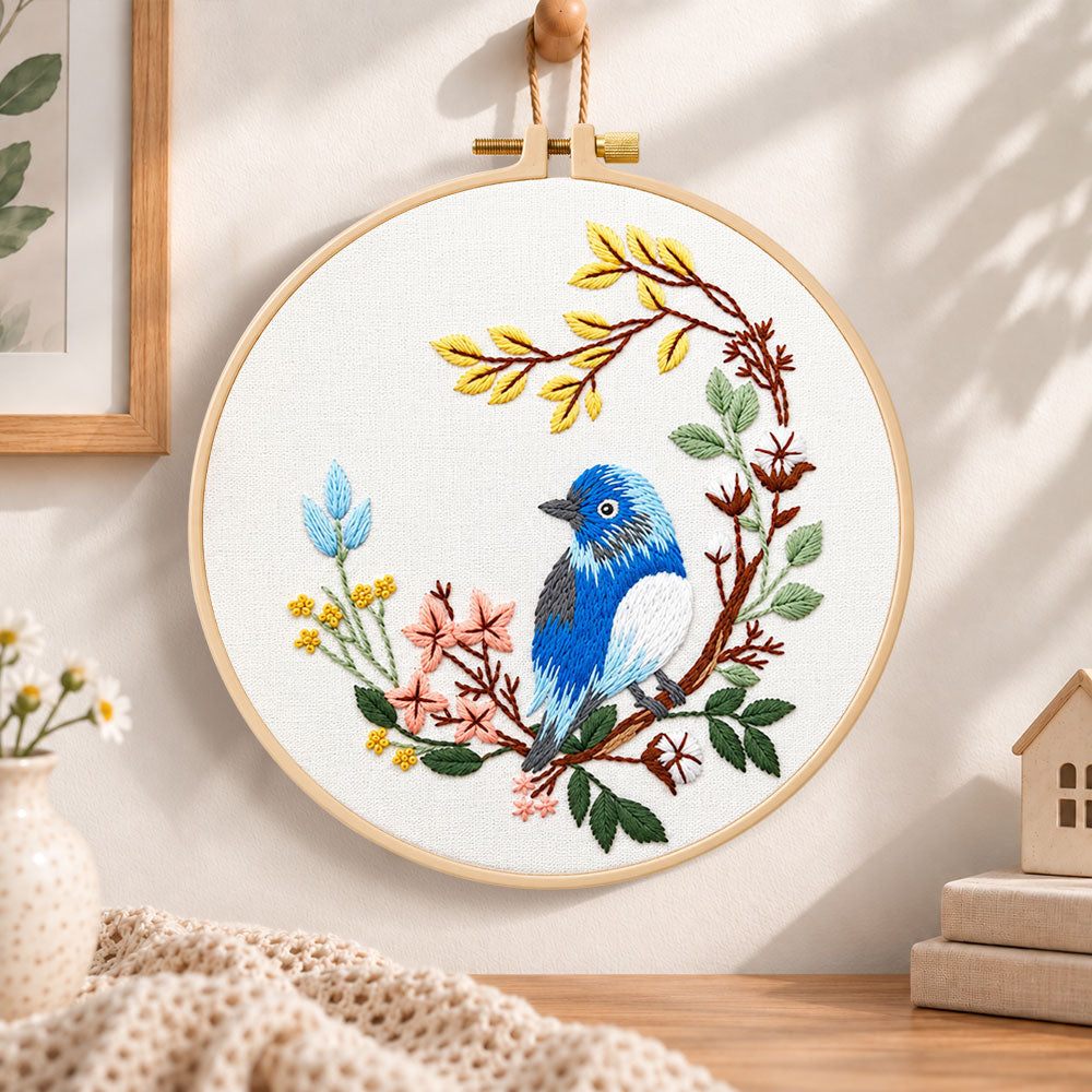 Blue bird on floral branch embroidery hoop wall art displayed as warm and cozy handmade home decor